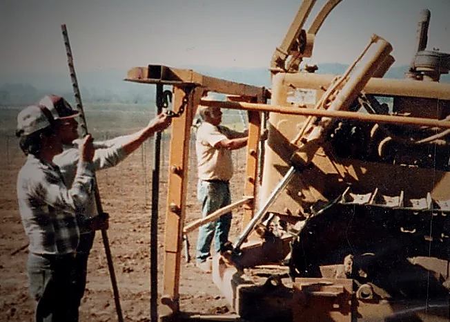 People working with machinery in the vineyard