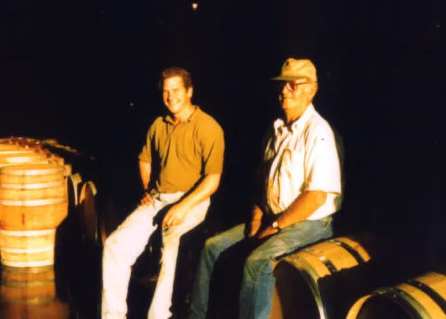 Two men sitting on wine barrels